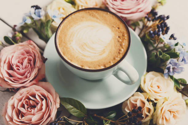 istock Cappuccino coffee and flowers composition on white wood 873881834