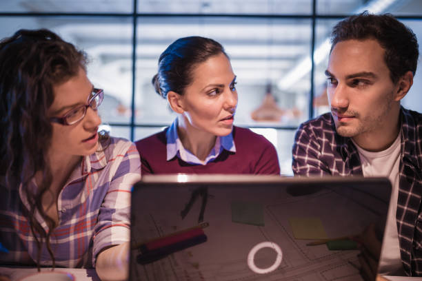 istock Working Late. Group of young architects working late in office 873882052