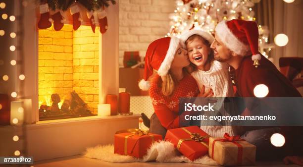 Feliz Navidad Padre De La Feliz Madre De Familia Y El Niño Con Regalos Cerca De Árbol Foto de stock y más banco de imágenes de Navidad