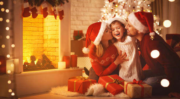 buon natale! felice famiglia madre padre e figlio con regali vicino albero - christmas family child christmas tree foto e immagini stock