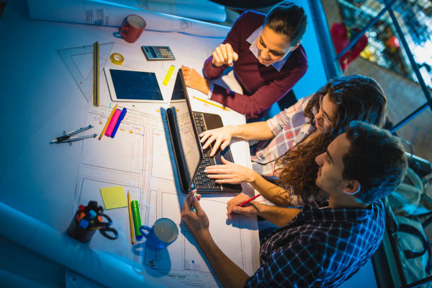 istock Working Late. Group of young architects working late in office 873882210
