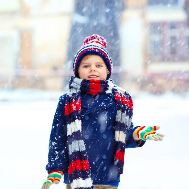 istock Happy kid boy having fun with snow in winter 873885952