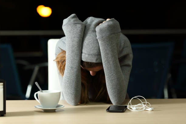 sad teenager complaining in a bar in the night - waiting telephone on the phone anxiety imagens e fotografias de stock