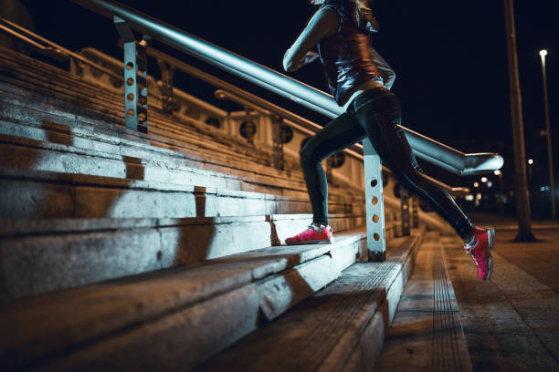 young woman running at night in a urban city area - night running imagens e fotografias de stock