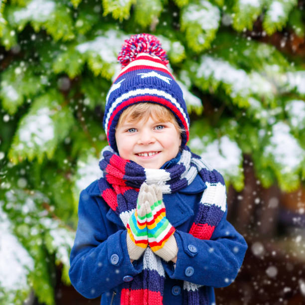 istock Happy kid boy having fun with snow in winter 873886428
