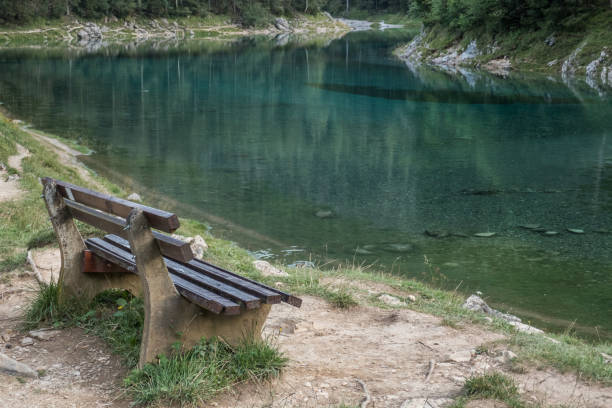 istock Bench at a mountain lake 873886460