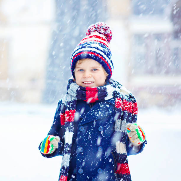 istock Happy kid boy having fun with snow in winter 873886644