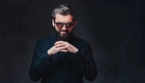 Photo of A man dressed in a suit and sunglasses.