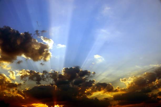 istock rays of the sun through black clouds in the blue sky 873891320