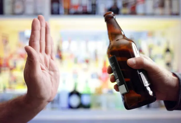 Hand rejecting alcoholic beer beverage concept for alcoholism and addiction