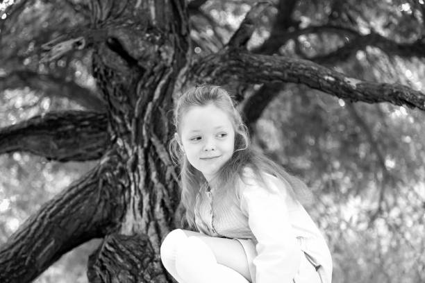 istock Girl sits in Park on a tree in the summer 873895368
