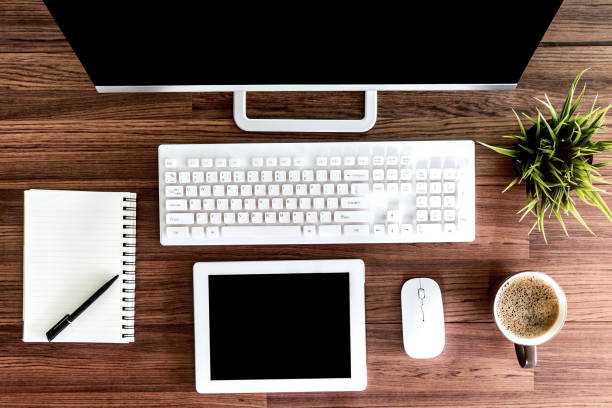 istock Computer with tablet and working place on wooden table 873898378