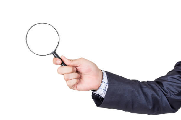 istock Businessman holding magnifying glass isolated on white background 873900022