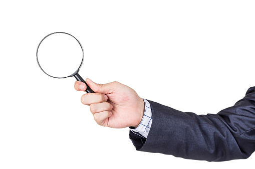 Businessman holding magnifying glass isolated on white background