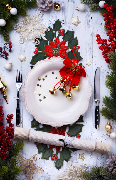 istock Christmas holiday dinner background; empty dish, cutlery and Christmas tree decoration 873902124