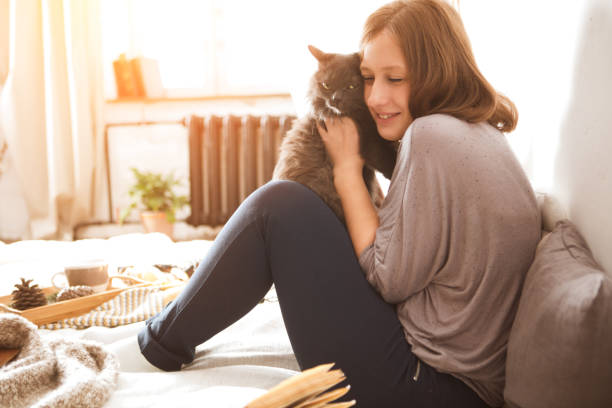 istock Young woman playing with cat in home. 873902906