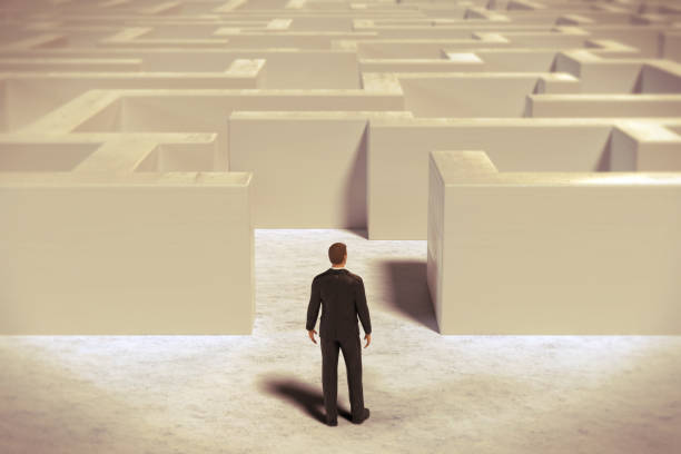 istock toy miniature businessman figurine entering a  white maze structure, 3d rendering 873903134