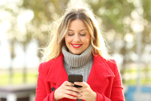 istock Front view of a woman using a smart phone in winter 873905940