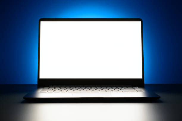 istock The laptop is on a blue background with a glowing white screen with copy space 873908796