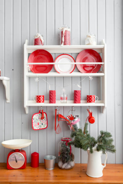 istock shelves with dishes. Interior light grey kitchen and red christmas decor. Preparing lunch at home on the kitchen concept. 873908870