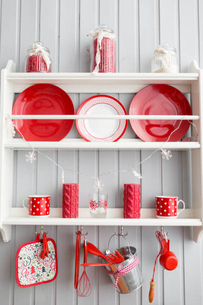 istock shelves with dishes. Interior light grey kitchen and red christmas decor. Preparing lunch at home on the kitchen concept. 873908942