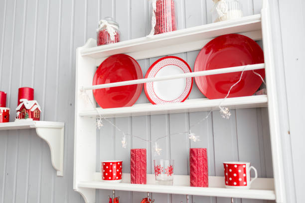 istock shelves with dishes. Interior light grey kitchen and red christmas decor. Preparing lunch at home on the kitchen concept. 873909252