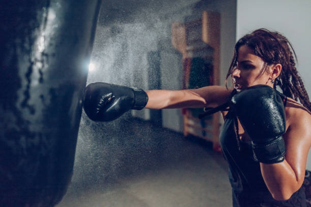 istock Female kickboxer training with a punching bag 873916418