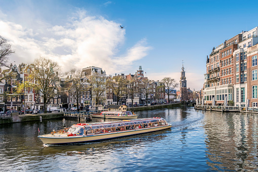 Panorama of Amsterdam with The Mint tower and touristic boat, The Netherlands