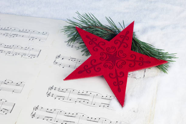istock Christmas decoration with pine tree, red star and musical score on a white snow background 873927614