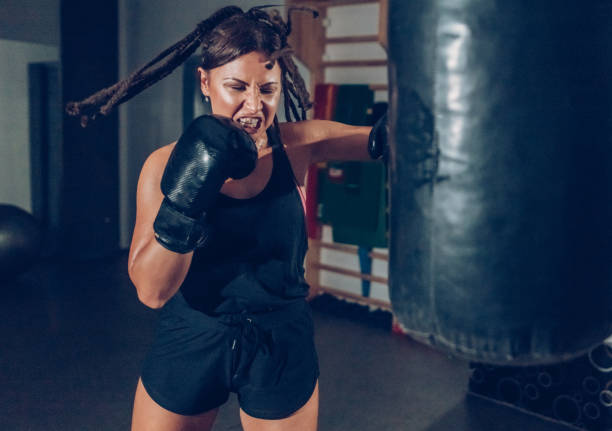 istock Female kickboxer training with a punching bag 873928298