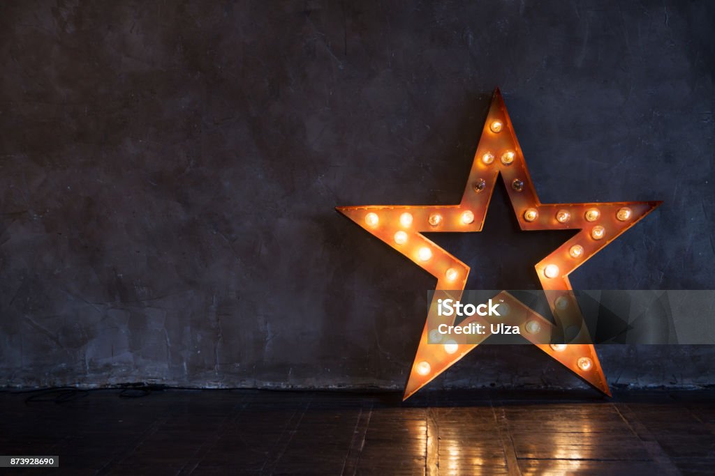 Étoile décorative avec des lampes sur un fond de mur. Intérieur moderne grungy - Photo de Forme étoilée libre de droits
