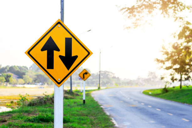 istock two-way traffic Signs on road with soft-focus and over light in the background 873931724