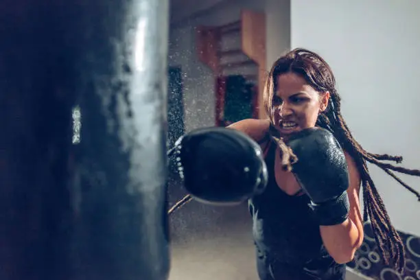 Female kickboxer fighter training with a punching bag