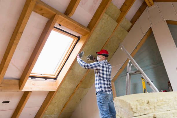 Man installing thermal roof insulation layer - using mineral wool panels. Attic renovation and insulation concept stock photo