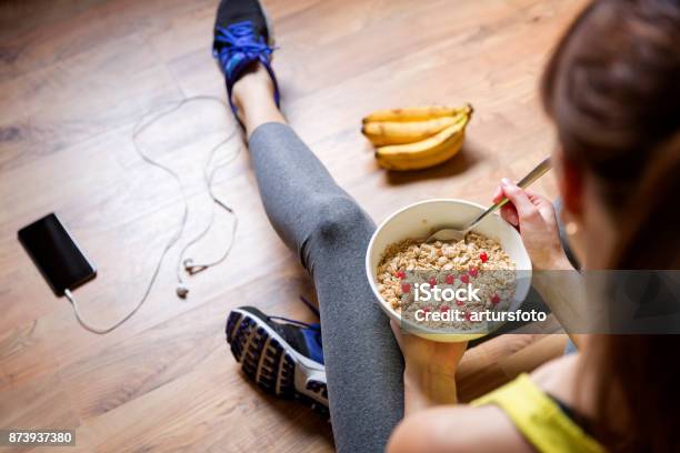 Photo libre de droit de Jeune Fille Mangeant Un Gruau Avec Des Baies Après Une Séance Dentraînement Remise En Forme Et Concept De Mode De Vie Sain banque d'images et plus d'images libres de droit de Manger