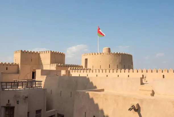 Rustaq castle with an Omani flag on a sunny day. Rustaq, Oman.