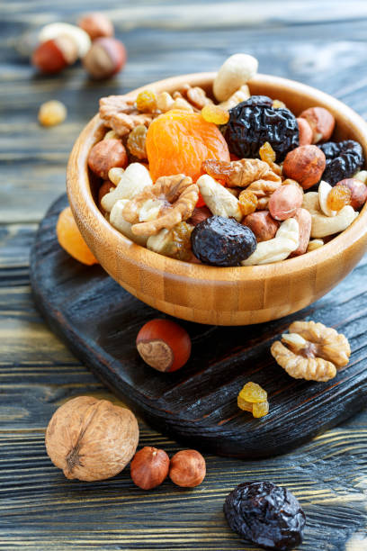 istock Dried fruit and mixed nuts in a wooden bowl. 873941702