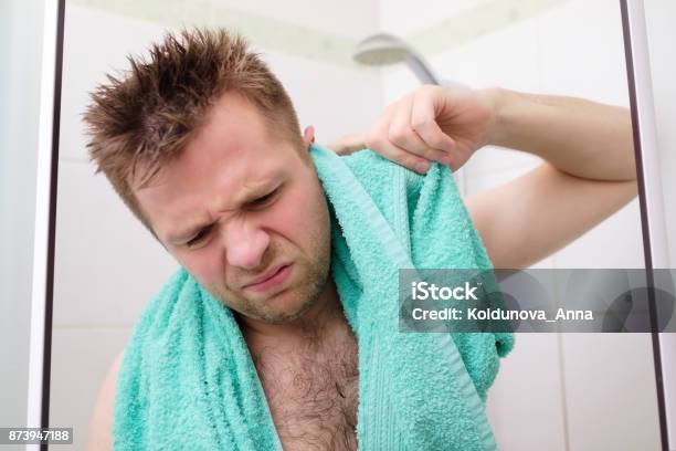 Young Man Cleaning His Ear While Taking A Shower And Standing Under Flowing Water Stock Photo - Download Image Now