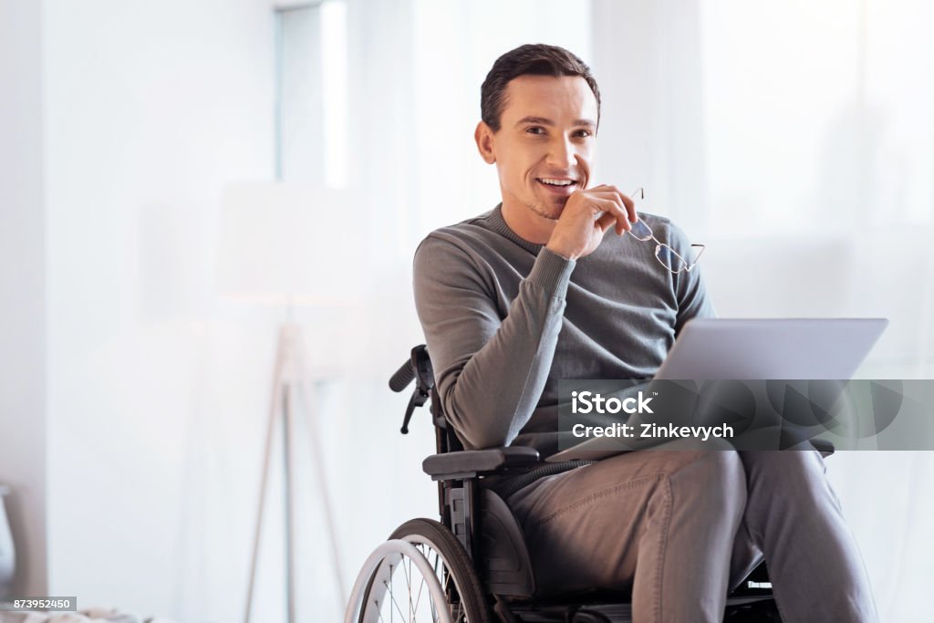 Positivo encantado hombre discapacitado mirando adelante - Foto de stock de Silla de ruedas libre de derechos