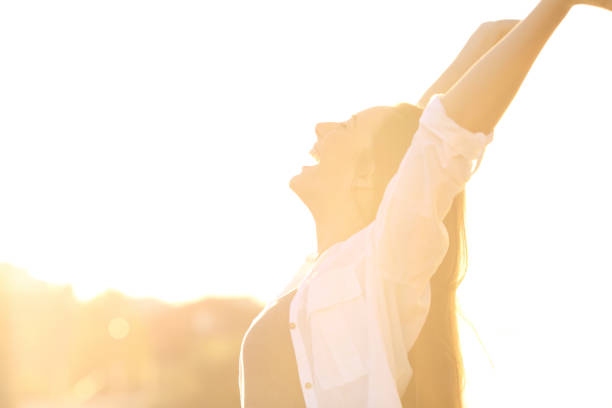 istock Excited woman raising arms at sunset 873953720