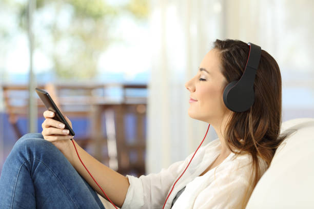 perfil de una mujer que escucha música relajante - tourist resort audio fotografías e imágenes de stock