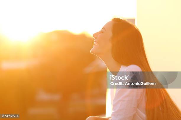 Photo libre de droit de Femme De Respiration Au Coucher Du Soleil Dans Un Balcon banque d'images et plus d'images libres de droit de Lumière du soleil