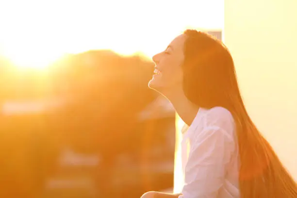 Photo of Woman breathing at sunset in a balcony