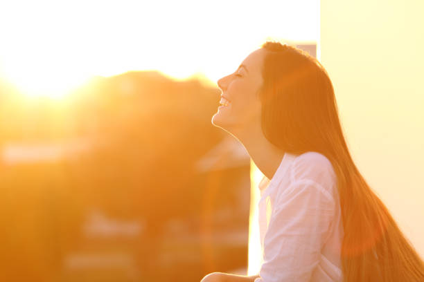 mulher respirando ao pôr do sol na varanda - inhaling breathing exercise one person relaxation - fotografias e filmes do acervo