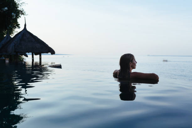 schwarze frauen-silhouette am infinitypool - vacations infinity pool relaxation women stock-fotos und bilder