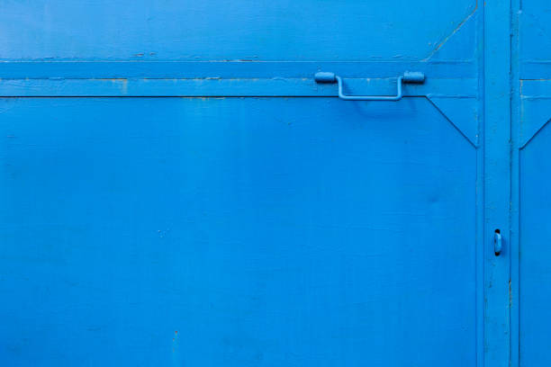 Old metal door with handle background. Rust surface covered with blue paint