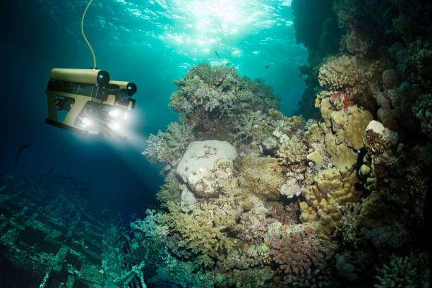 Robot inspects a sunken ship deep under water stock photo