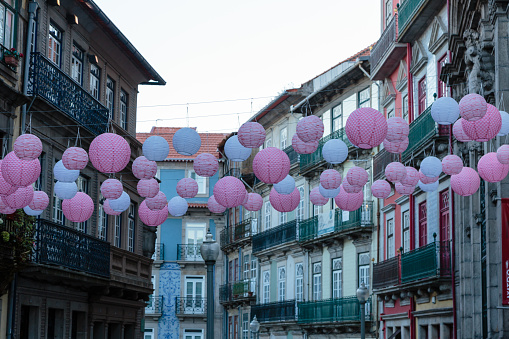 Pink Spherical Paper Lanterns Hanged in Porto Street among Houses, Portugal.
