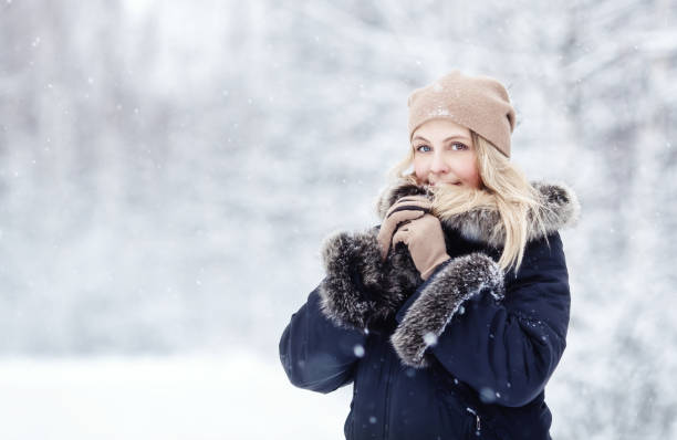 Pretty blonde woman in winter forest stock photo