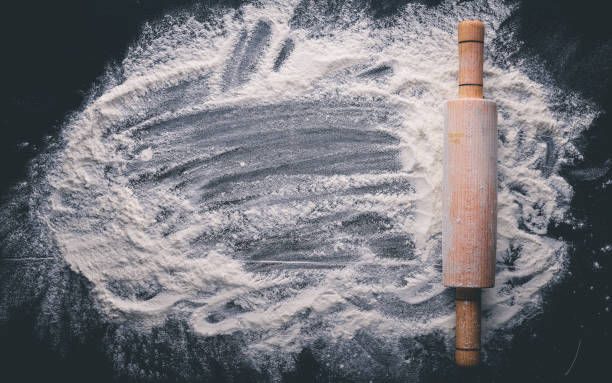istock Rolling pin and white flour on a dark background. Free space for text . Top view. 873990714